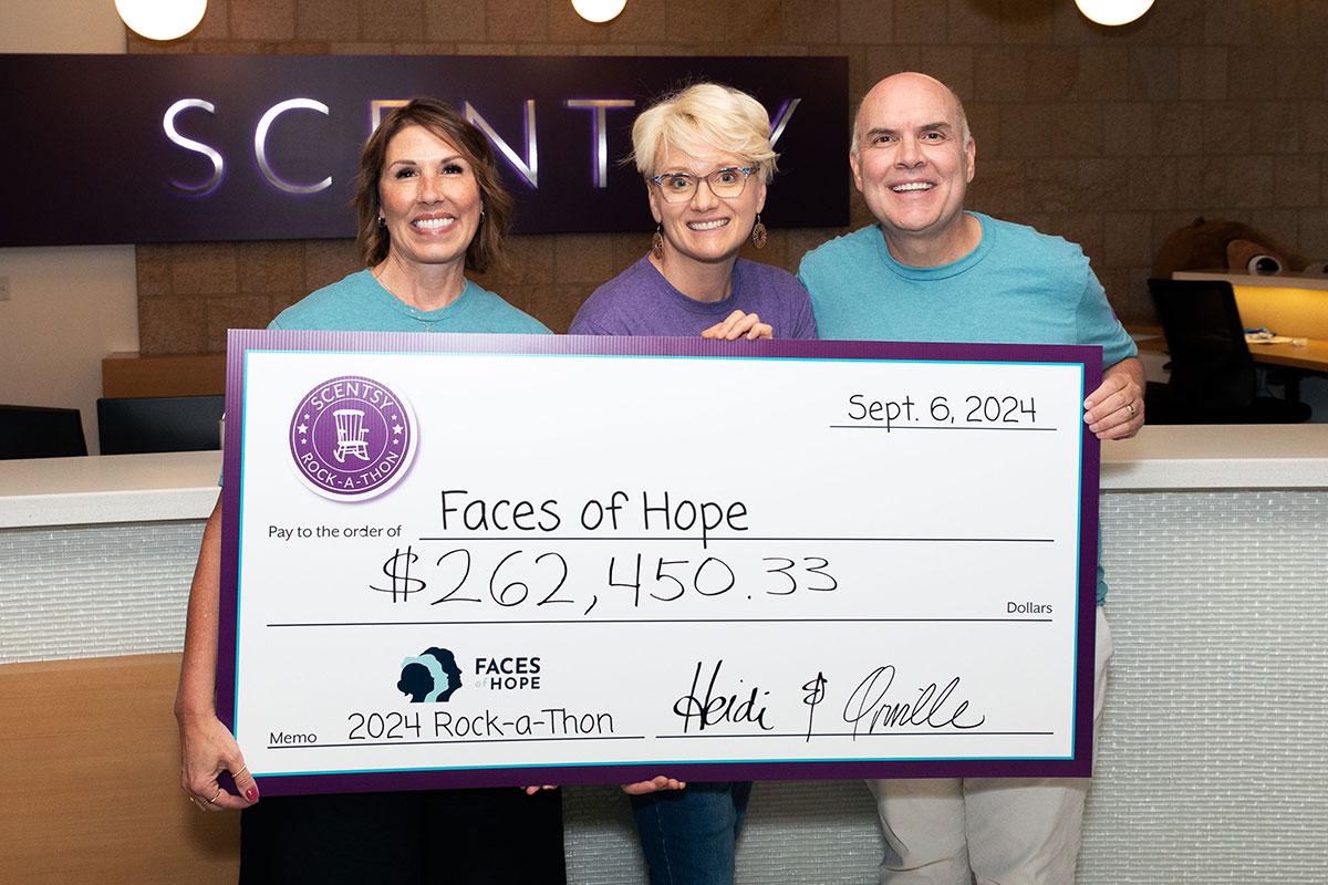 two women and one man holding an oversized check for $262,450.33