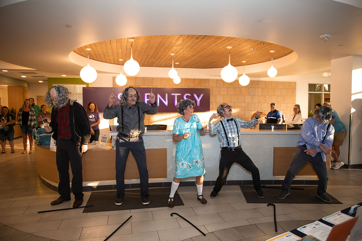 five people in costume as old people performing a dance