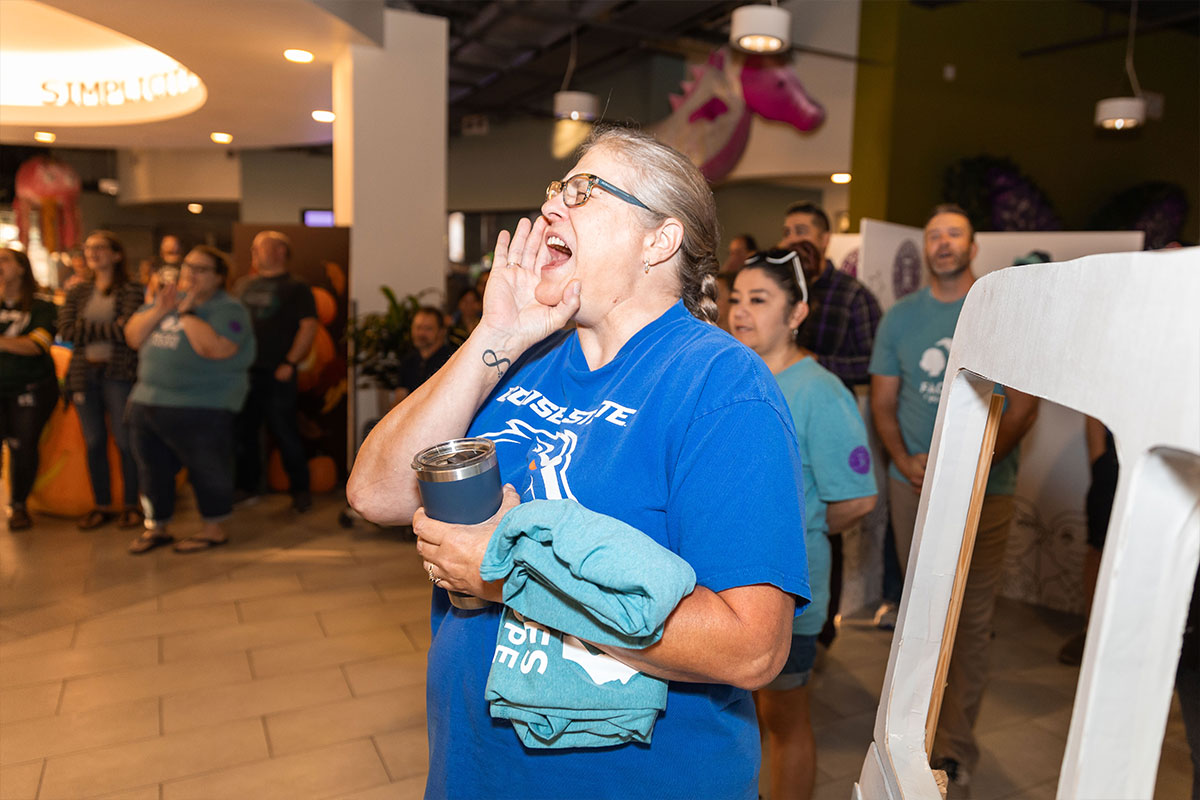 woman in blue tee shirt cheering for event