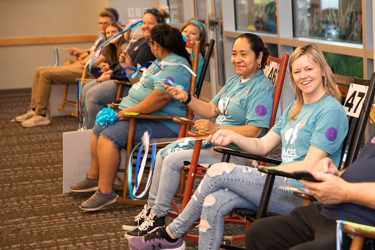 group of happy people rocking in rocking chairs and waving