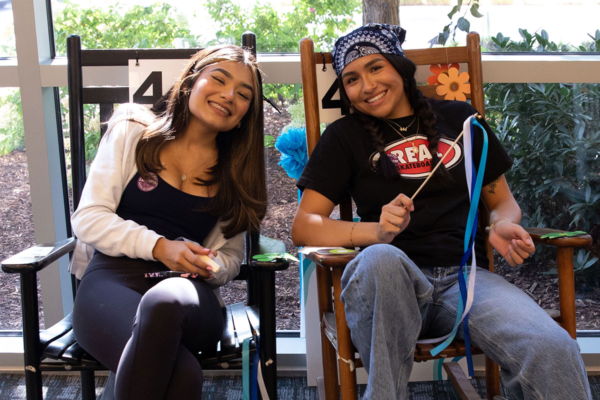 two happy, young women rocking in rocking chairs