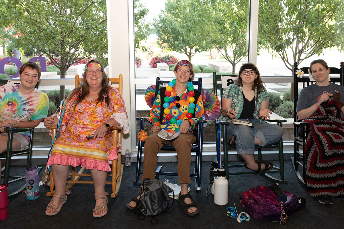 group of happy people dressed up as hippies rocking in rocking chairs